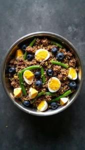 Homemade anti-inflammatory dog food with beef, quinoa, eggs, blueberries and green beans for arthritis relief