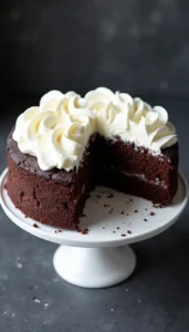 Homemade dog birthday cake with carob and yogurt frosting on white cake stand