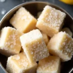 Homemade frozen peanut butter banana dog treats cubes in metal bowl with fresh bananas and peanut butter jar