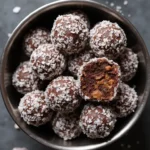 Homemade No-Bake Carob and Coconut Dog Treats in a dark bowl showing texture and peanut butter center