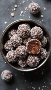 Homemade No-Bake Carob and Coconut Dog Treats in a dark bowl showing texture and peanut butter center