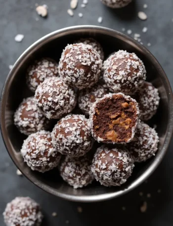 Homemade No-Bake Carob and Coconut Dog Treats in a dark bowl showing texture and peanut butter center